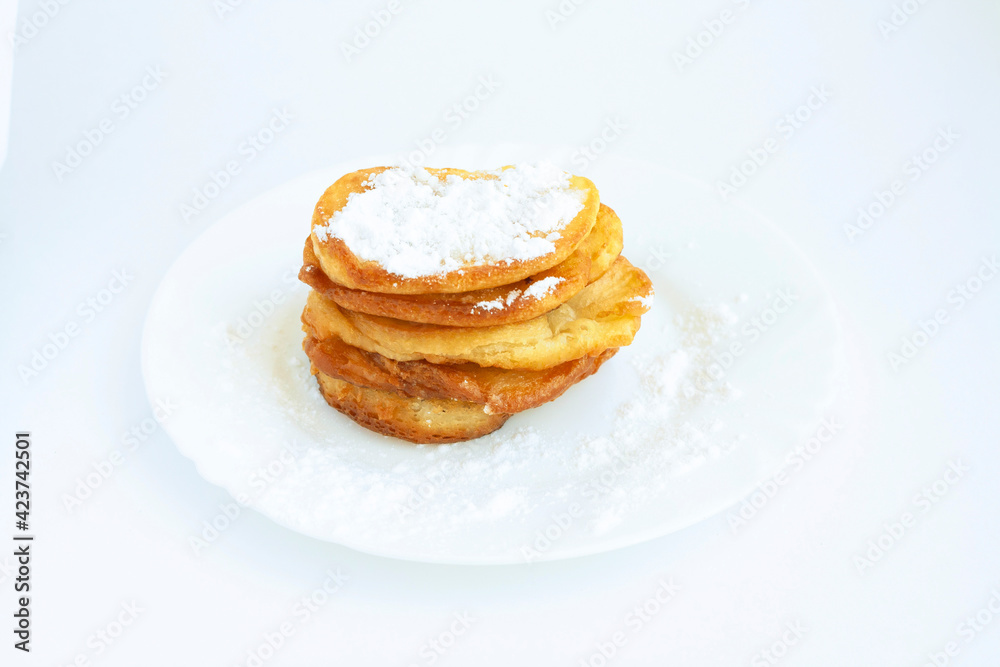 Pancakes with powdered sugar on a plate, isolated on a white background Pancakes with powdered sugar on a plate, isolated on a white background