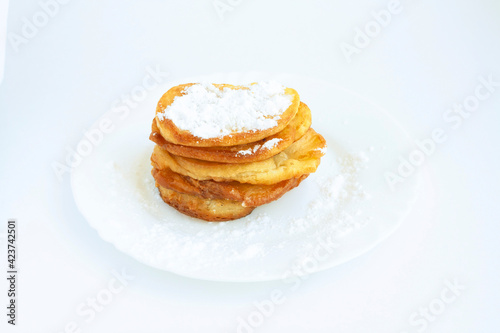 Pancakes with powdered sugar on a plate, isolated on a white background