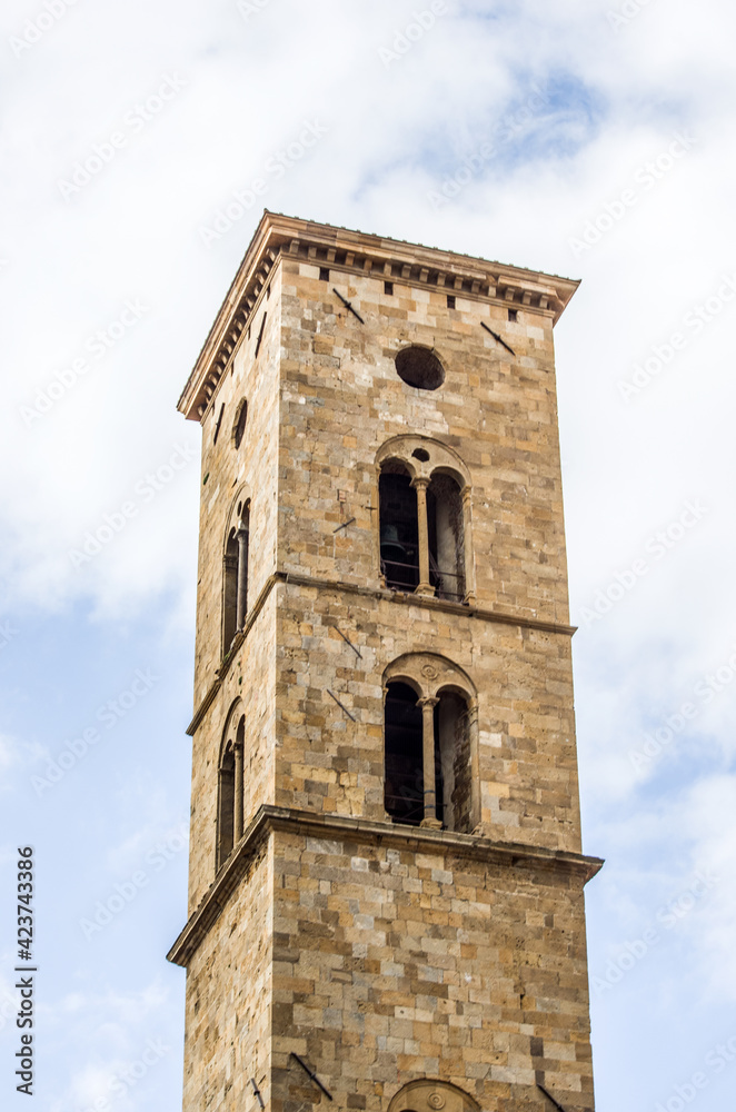 ancient bell tower with bells and flag of the historic city