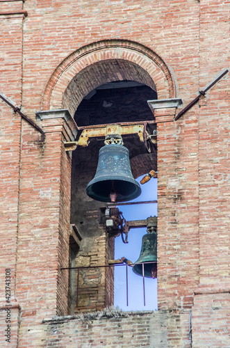 ancient bell tower with bells and flag of the historic city