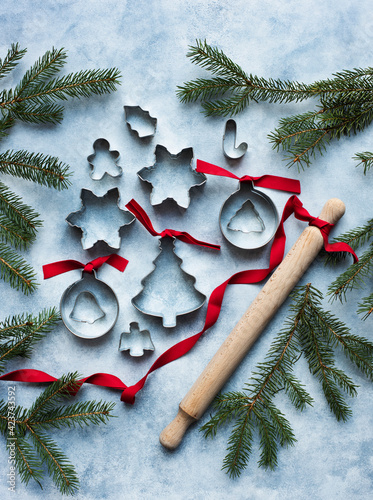 Metal cookie cutters of different shapes with rolling pin