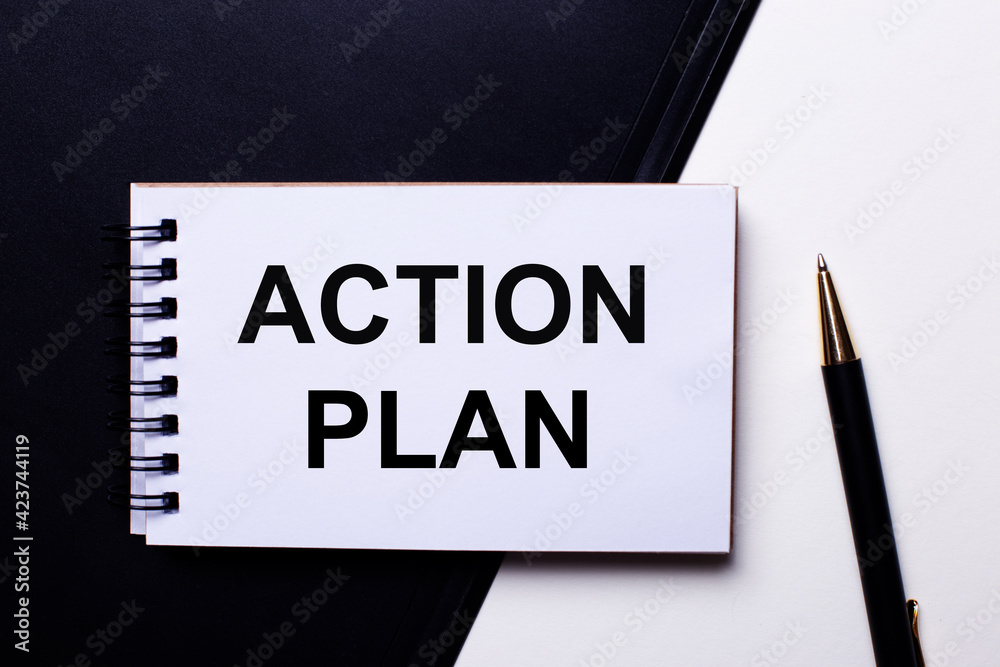 The words ACTION PLAN written in red on a black and white background near the pen The words ACTION PLAN written in red on a black and white background near the pen