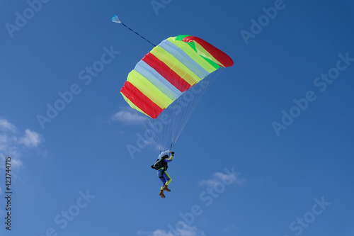 Skydiving. A parachute is in the blue sky.