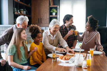 Multi ethnic and generational family cooking in kitchen together