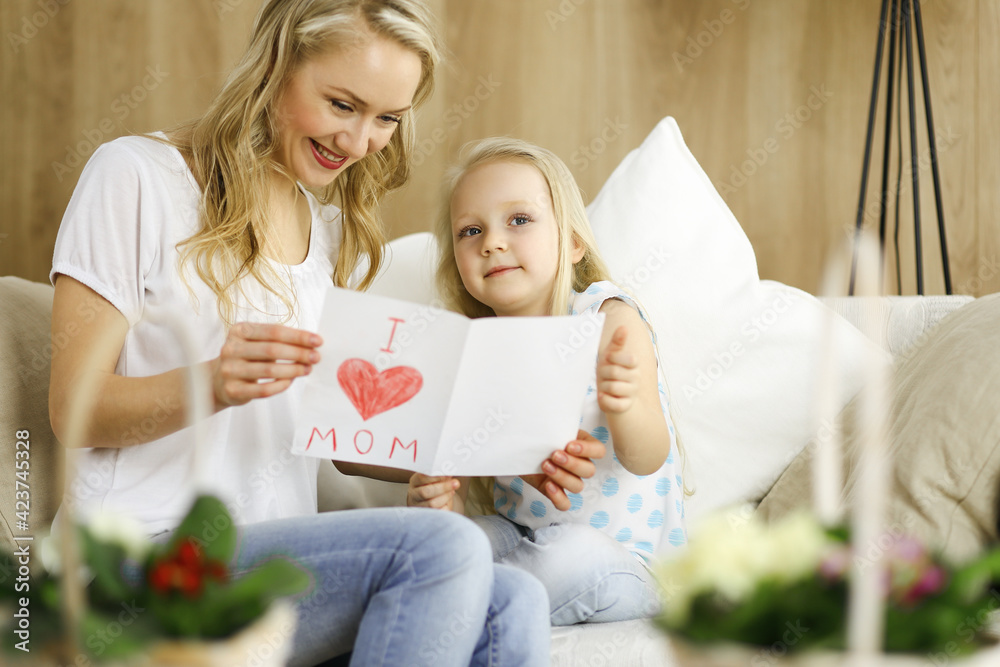 Happy mother day. Child daughter congratulates mom and gives her postcard with heart drawing. Family and childhood concepts Happy mother day. Child daughter congratulates mom and gives her postcard with heart drawing. Family and childhood concepts