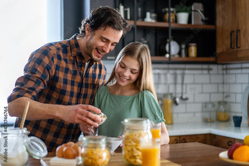 Happy caucasian father and daughter preparing cookie in kitchen. Cooking together happy family time.