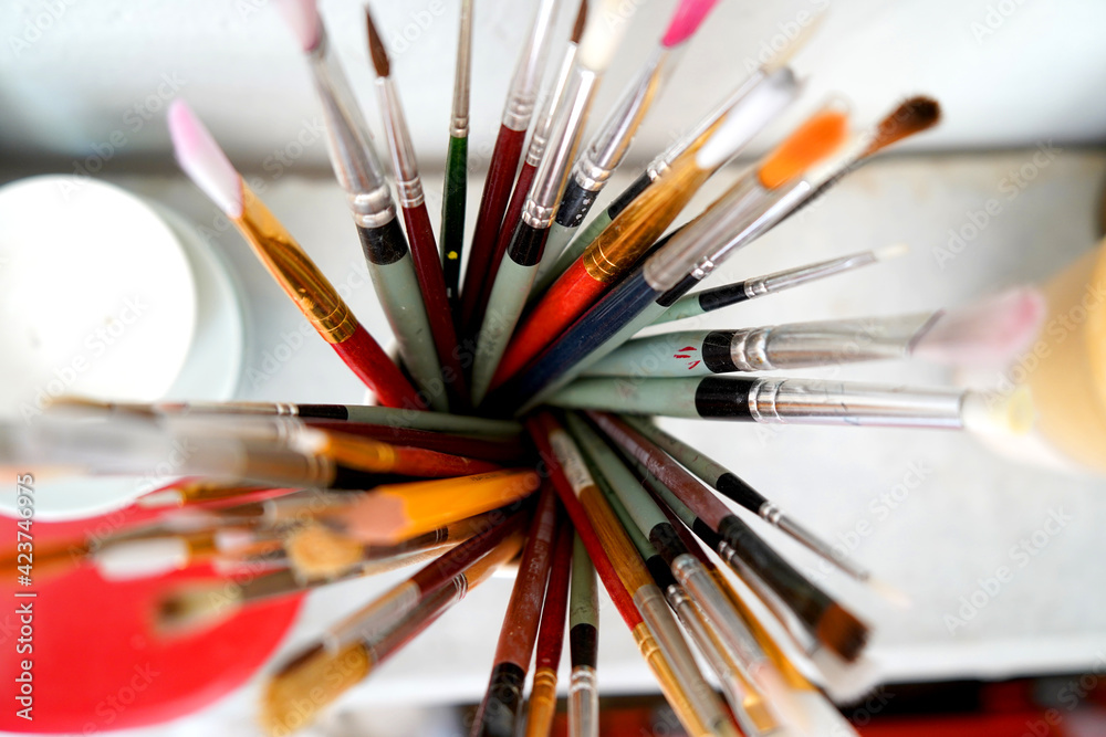 Detail of paint brushes and bright paint in an artist’s studio Detail of paint brushes and bright paint in an artist’s studio