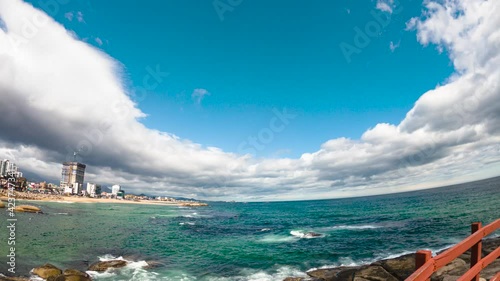 Clouds flow through blue sky time-lapse took at the sea coast. Beautiful nature scene took with 4K 30fps.