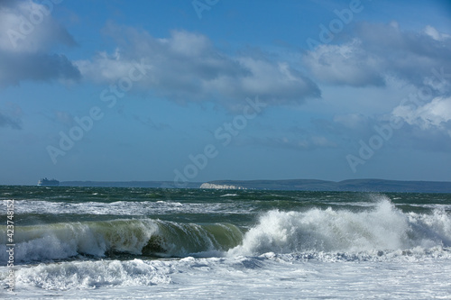 Stormy weather at the beach with crashing waves under a majestic blue sky