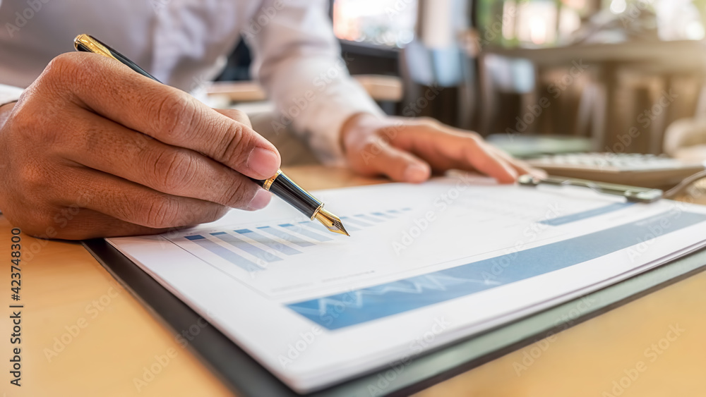 Businessman discussing the charts and graphs showing the results of their successful teamwork. Business concept. Businessman discussing the charts and graphs showing the results of their successful teamwork. Business concept.