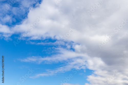 Detail of a white cloud in a bright blue sky. Dark rain clouds displace the blue sky. Storm is coming. Cumulus clouds on a sunny Day. 