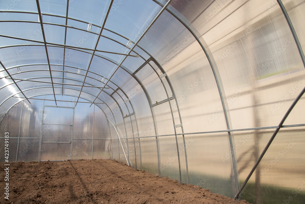 Empty greenhouse, prepared for planting vegetables in the spring. Home production of vegetables. Empty greenhouse, prepared for planting vegetables in the spring. Home production of vegetables.