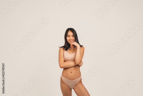 Photo of natural woman face, wears underwear. Isolated over white background. Natural beauty and health. Clean skin and cute smile
