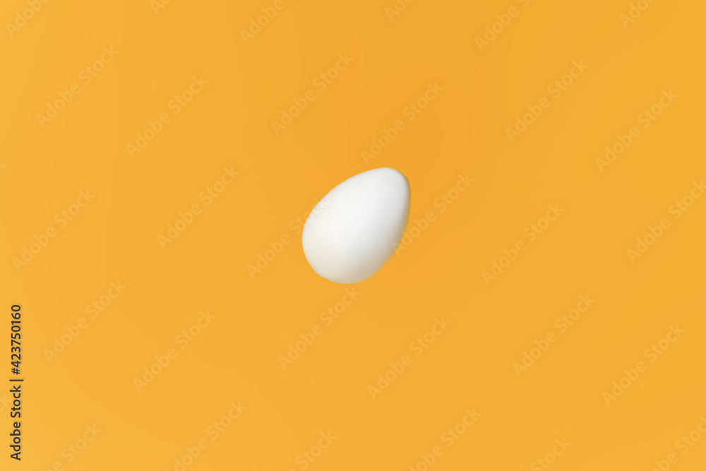 White egg flying on yellow background, easter concept. Preparing for Christianity holiday Easter. Happy easter card. Copy space for text