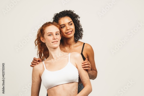 Photo of natural multiracial women, body positive. Feminist females in underwear smile and look happy, isolated on white background. Concept natural beauty and girl power © Ivan