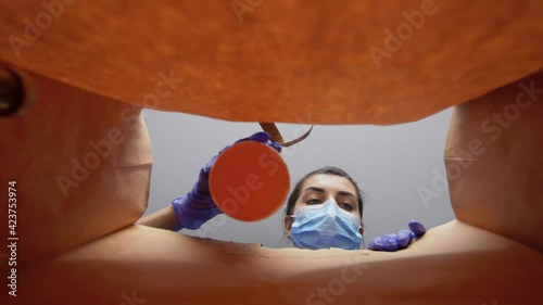 health protection, delivery and pandemic concept - woman in protective medical gloves and mask packing food into paper bag photo