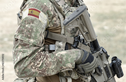 Fotografie Soldier with assault rifle and flag of Spain on military uniform
