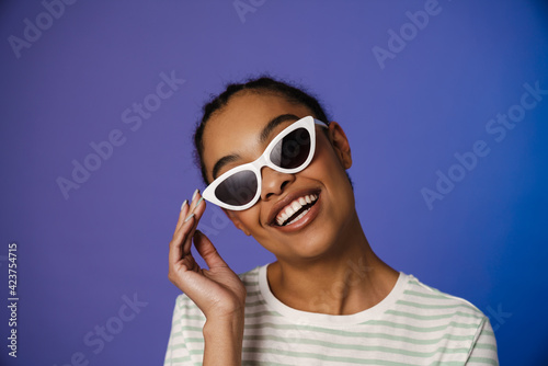 Young black woman in sunglasses smiling at camera