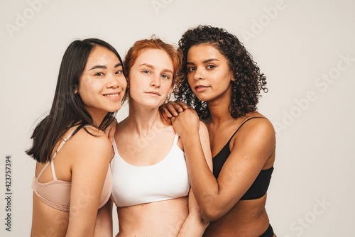 Photo of optimistic young women, multiracial friends wear underwear, hug each other and show their love. Concept natural beauty and girl power. © Ivan