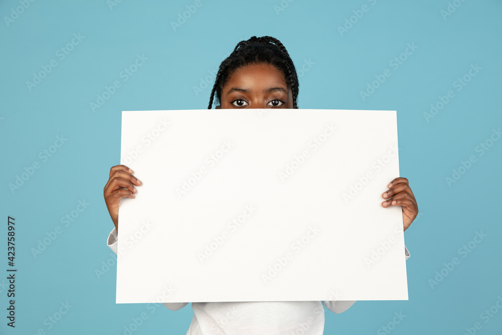Handsome african little girl portrait isolated on blue studio background with copyspace Handsome african little girl portrait isolated on blue studio background with copyspace