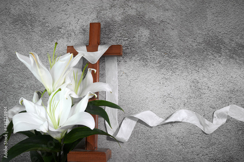 Photography Cross with white lilies on grey background