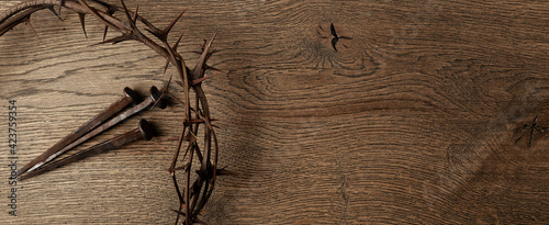 Fotografija Crown of thorns with three nails on wooden background
