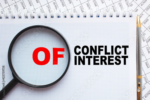 text CONFLICT OF INTEREST in notepad. office furniture on the table. business and finance