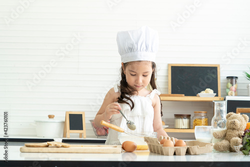 Daughter, cute children, wearing chef hats, teaching building in the kitchen 