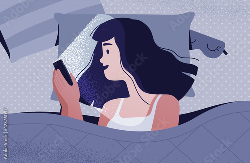 A woman with a smartphone in her hands lies on the bed in the dark. The light from the phone dazzles her face and hurts her eyes. Gadget addiction concept