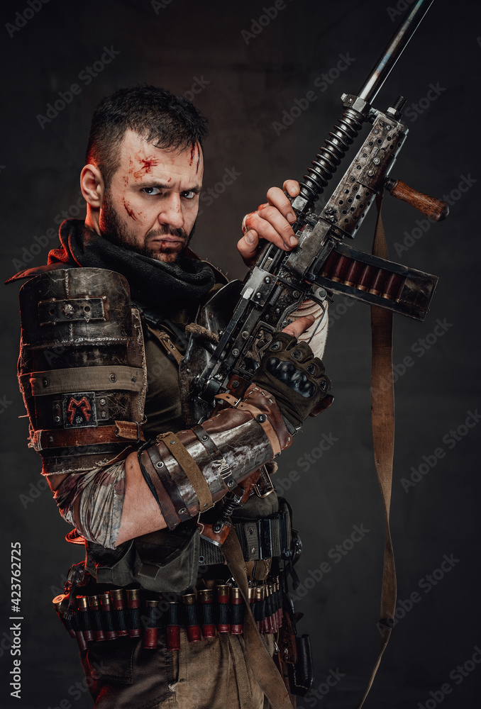 Armed apocalyptic man poses with shotgun in dark background Armed apocalyptic man poses with shotgun in dark background