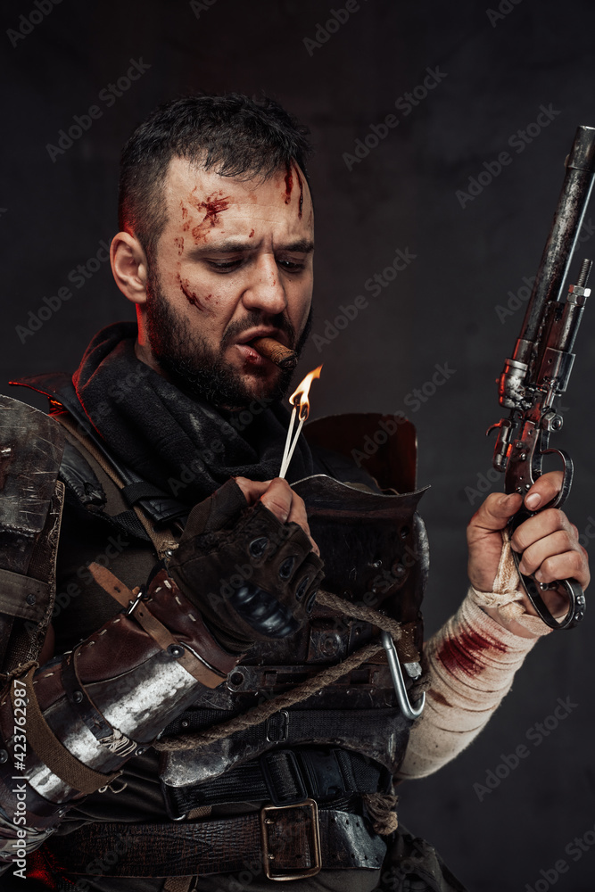 Serious apocalyptic fighter smoking cigar and holding gun Serious apocalyptic fighter smoking cigar and holding gun