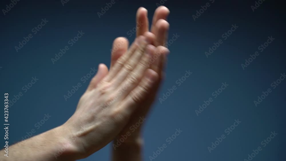 Close up shot of human hand raising, with hand clapping gesture. The man clapping their palms quickly and repeatedly to express appreciation or approval. Seen in isolate blue screen in background. Close up shot of human hand raising, with hand clapping gesture. The man clapping their palms quickly and repeatedly to express appreciation or approval. Seen in isolate blue screen in background.