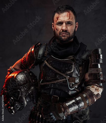 Bearded apocalyptic survivor with helmet in dark background