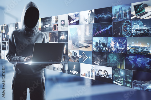 Online piracy concept with noface hacker with laptop on media wall with video archive background. photo