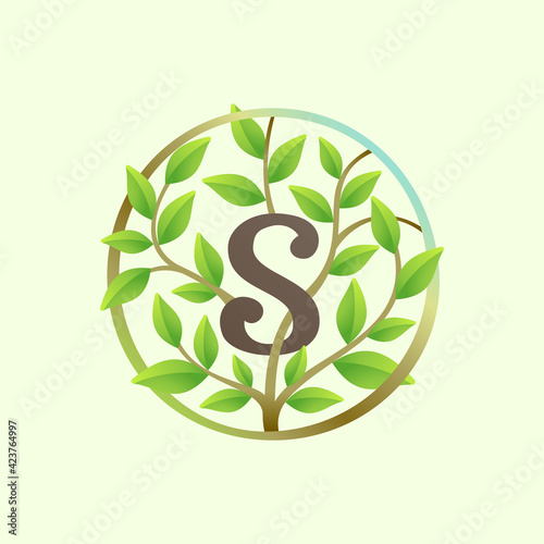 S letter logo made of twisted tree branches and green leaves in circle.