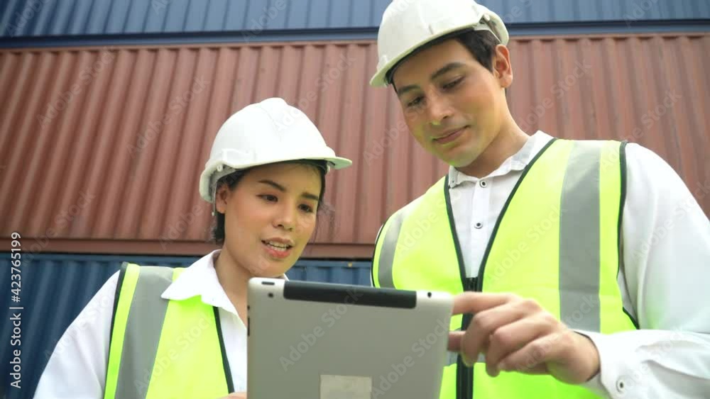 asian foreman and harbor worker woman discussion and using digital tablet checking list inventory loading Containers box together at warehouse logistic in Cargo . import export shipping business asian foreman and harbor worker woman discussion and using digital tablet checking list inventory loading Containers box together at warehouse logistic in Cargo . import export shipping business