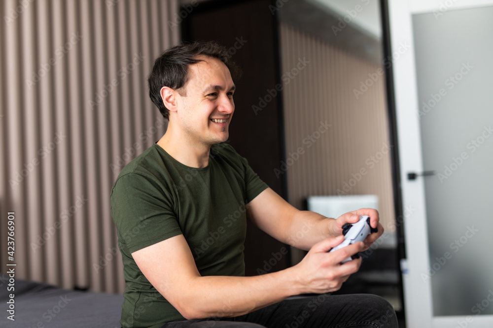 Excited young man playing video game on sofa Excited young man playing video game on sofa
