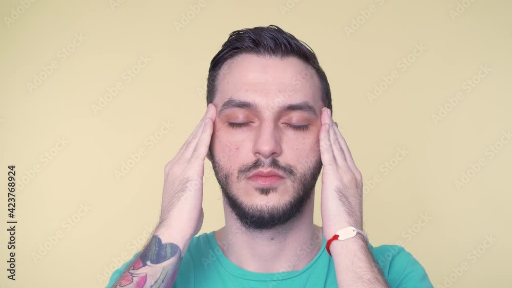 Young bearded man suffer from strong pain or headache. Hold fingers close to side of head. Young bearded man suffer from strong pain or headache. Hold fingers close to side of head.