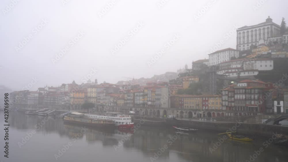 Buildings Of Ribeira District On Embankment Of Douro River In Porto, Portugal On A Foggy Morning. wide shot Buildings Of Ribeira District On Embankment Of Douro River In Porto, Portugal On A Foggy Morning. wide shot