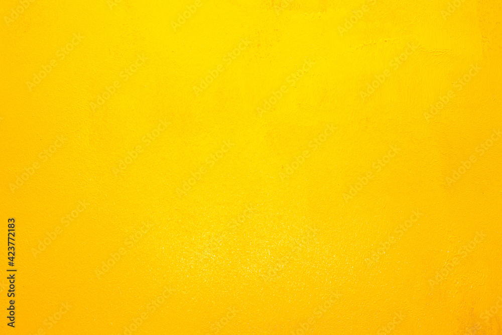 The wall is painted in a bright yellow illuminating light with smudges of paint. Soft focus. Positive mood. Place for text, template, natural background The wall is painted in a bright yellow illuminating light with smudges of paint. Soft focus. Positive mood. Place for text, template, natural background