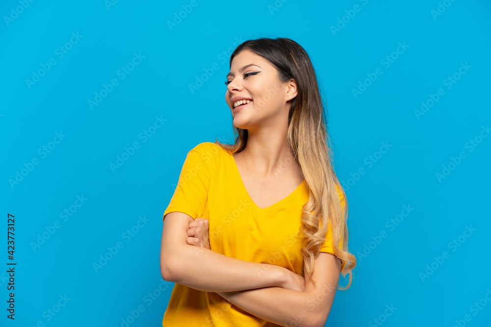 Young Russian girl isolated on blue background happy and smiling Young Russian girl isolated on blue background happy and smiling