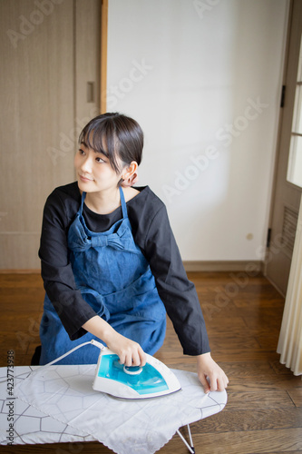 家事、アイロンがけをする女性