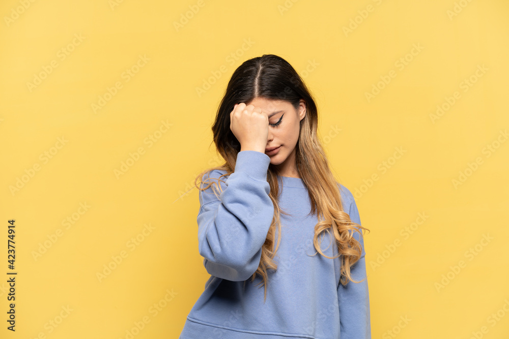 Young Russian girl isolated on yellow background with headache Young Russian girl isolated on yellow background with headache