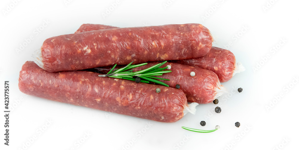 Raw meat sausages. Rosemary, pepper. White background. Raw meat sausages. Rosemary, pepper. White background.