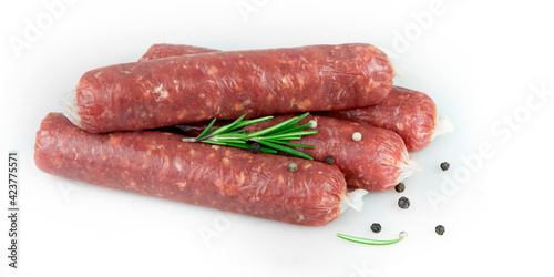 Raw meat sausages. Rosemary, pepper. White background.