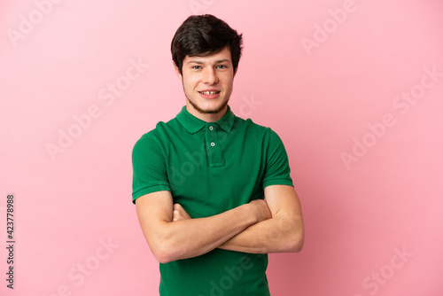 Young Russian man isolated on pink background keeping the arms crossed in frontal position