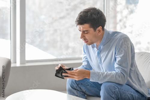 Sad man with empty wallet a...