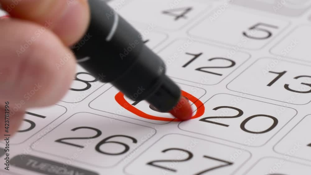 Paper Calendar, daily planner. Mark the date on a paper calendar. Hand with a felt-tip pen mark date on a calendar. Deadline for a business appointment, meeting concept.