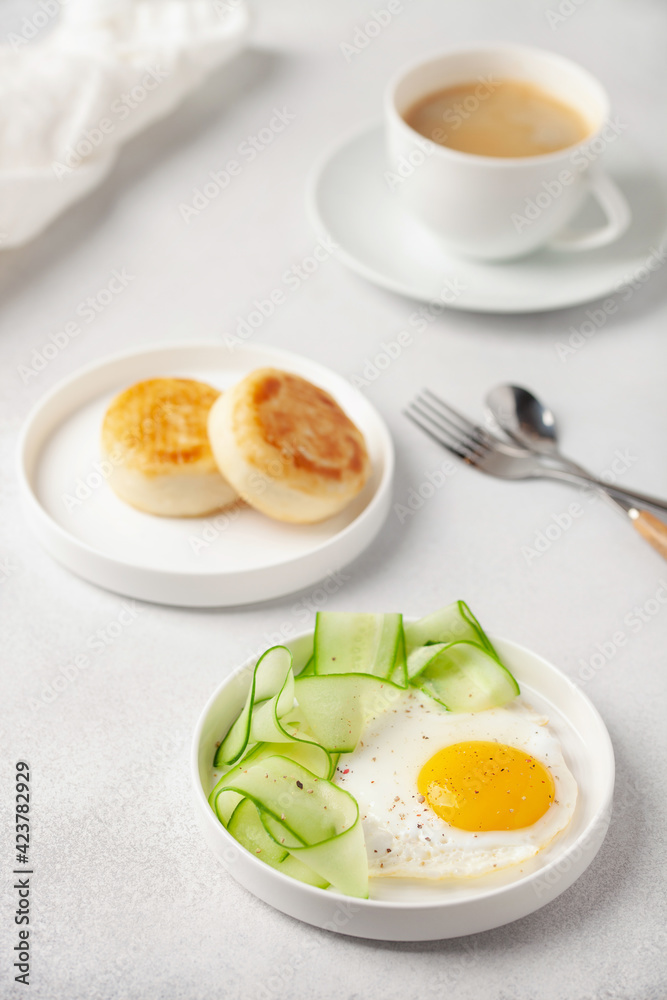 Eggs, cucumber in a plate and curd pancakes on the table. Healthy breakfast Eggs, cucumber in a plate and curd pancakes on the table. Healthy breakfast