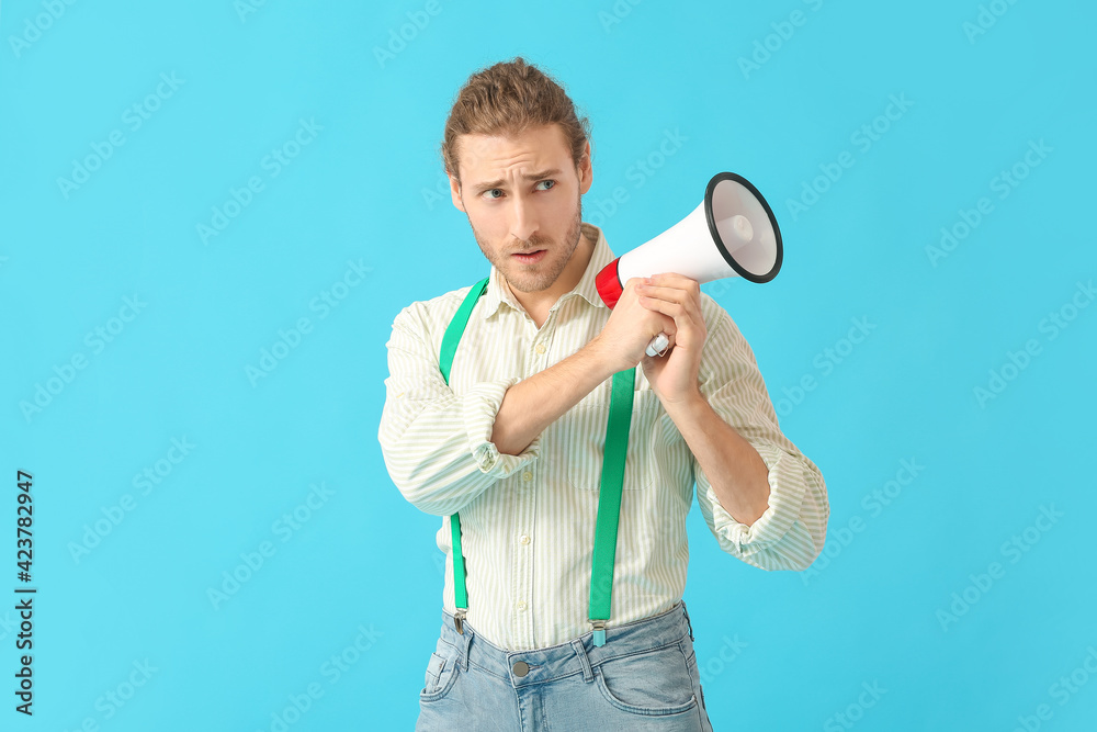 Young man with megaphone on color background Young man with megaphone on color background